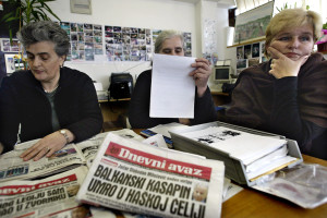 Superstiti del massacro di Srebrenica leggono sui giornali le ultime notizie sulla morte di Slobodan Milosević. Sarajevo marzo 2006 photo Danilo Krstanovic