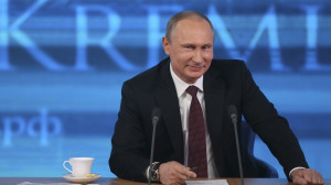Russian President Vladimir Putin smiles as he takes part in a televised news conference in Moscow