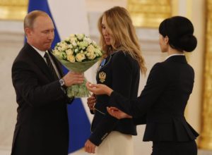 Il presidente regala un mazzo di fiori a lla medaglia d’oro nel nuoto sincronizzato Natalia Ishchenko (Epaa)