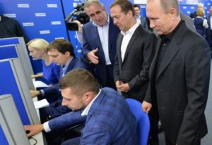 TOPSHOT - Russian President Vladimir Putin (R) and Russian Prime Minister and chairman of the United Russia political party Dmitry Medvedev (2R) visit the party's election campaign headquarters during parliamentary elections in Moscow on September 18, 2016. Russia's ruling party won 49.8 percent of the vote in nationwide legislative elections, partial results showed, as it is set to dominate a new parliament made up of Kremlin loyalists. / AFP PHOTO / SPUTNIK / Alexei Druzhinin